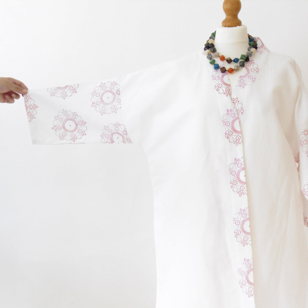 White linen kimono jacket showing floral mandala block print detail with fabric held open