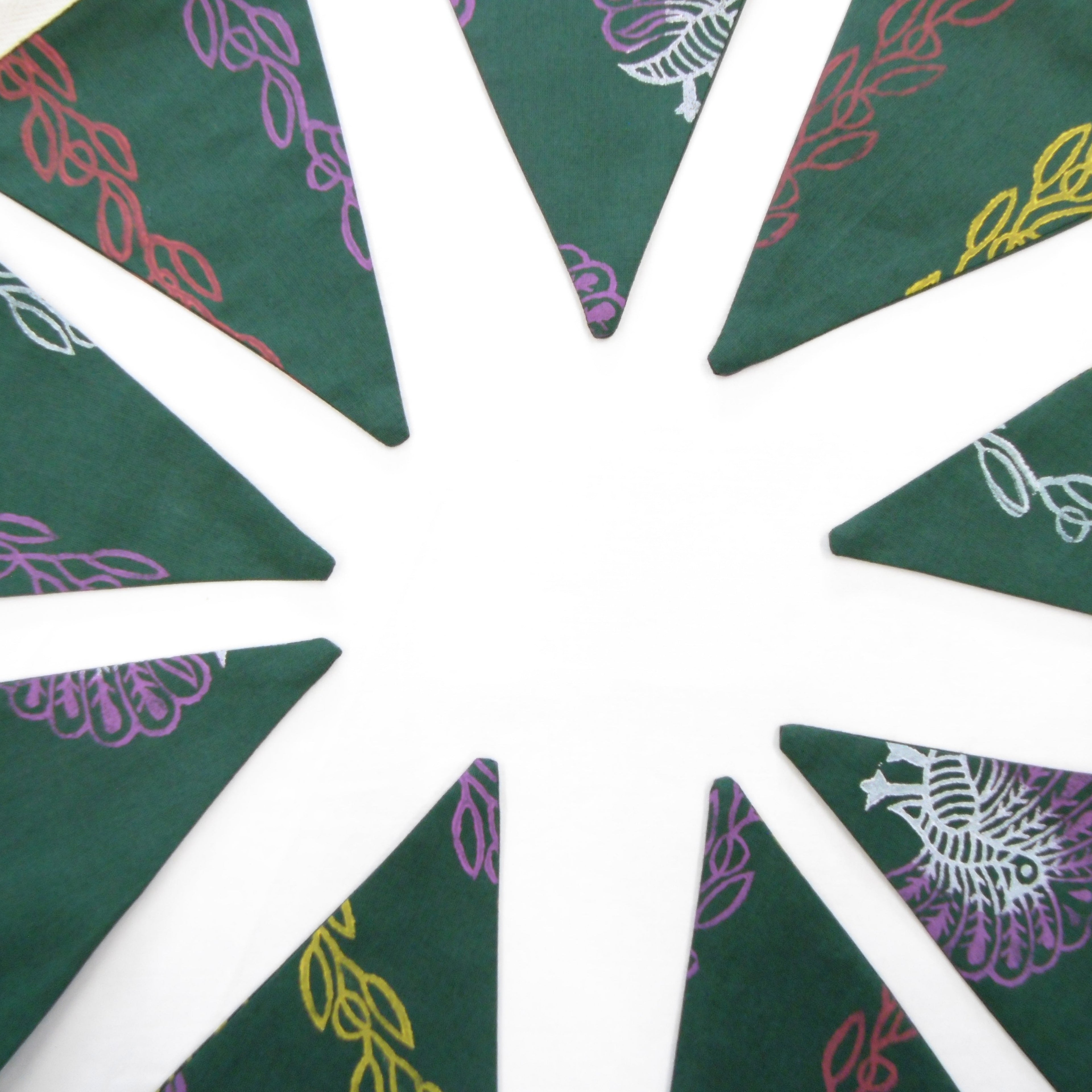 Green cotton bunting flags fanned out showing multicoloured vine and peacock block print design