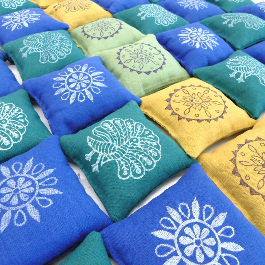 Close up of hand block printed Rang Bazaar lavender sachets in blue teal and yellow with traditional Pakistani peacock and mandala block print designs by Naila Ahmad London