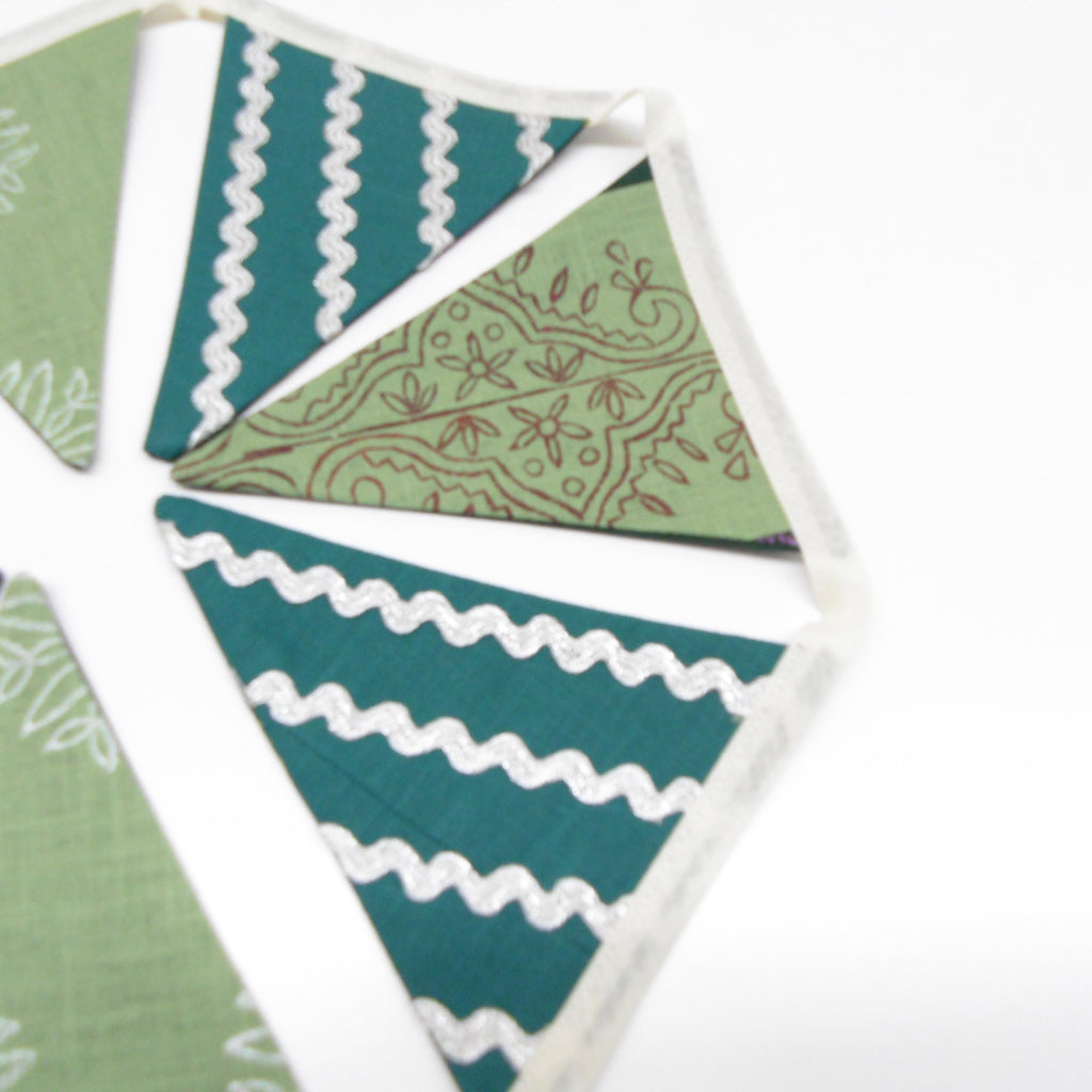 Mixed green cotton linen bunting flags with silver ricrac embellishment and hand printed vine and floral patterns