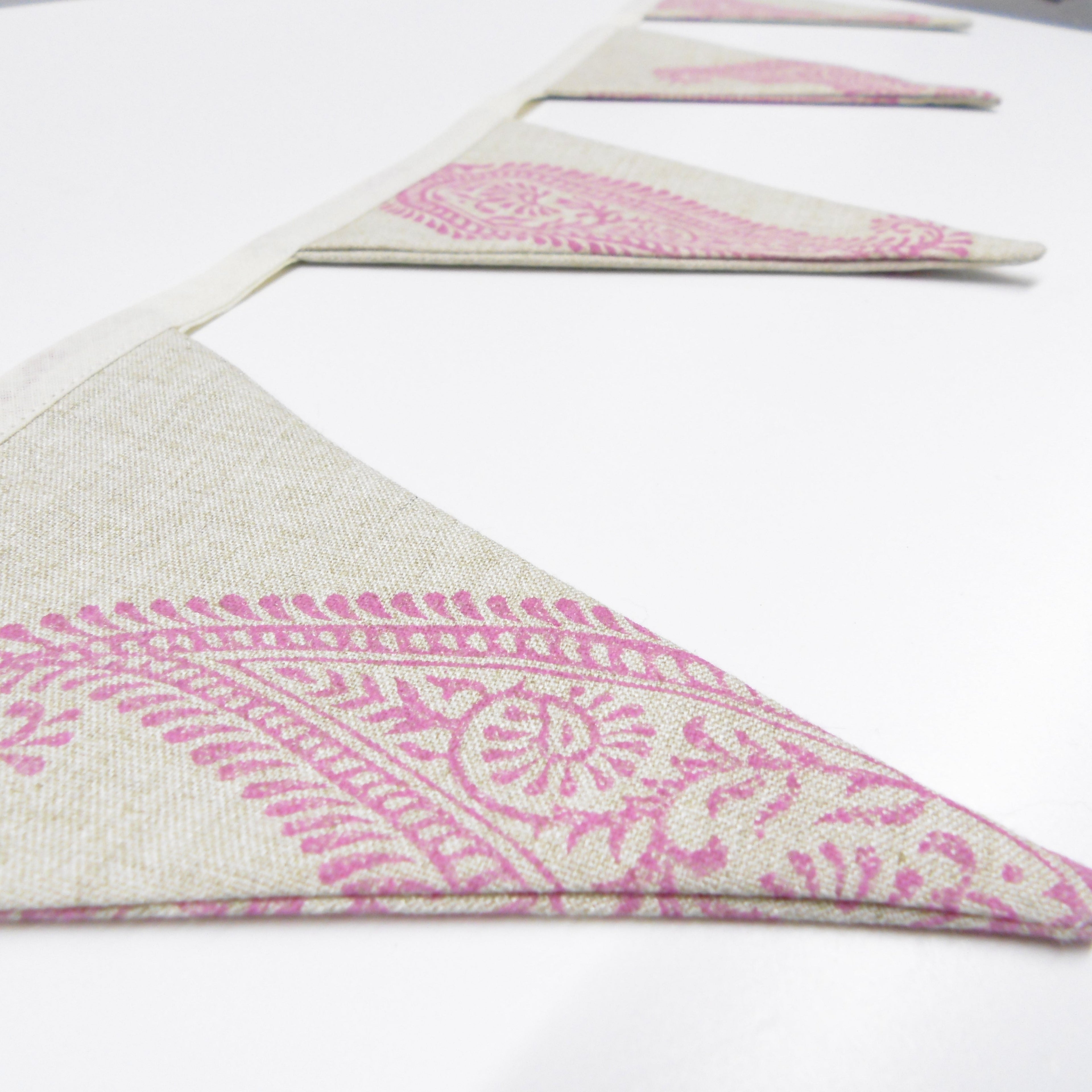 Side view of pink hand block printed linen bunting flags showing texture and paisley motif detail