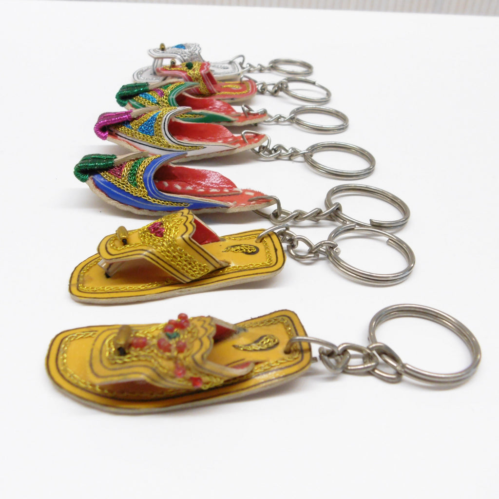 Close up side view of miniature leather Pakistani chappal keyrings with colourful embroidered detailing