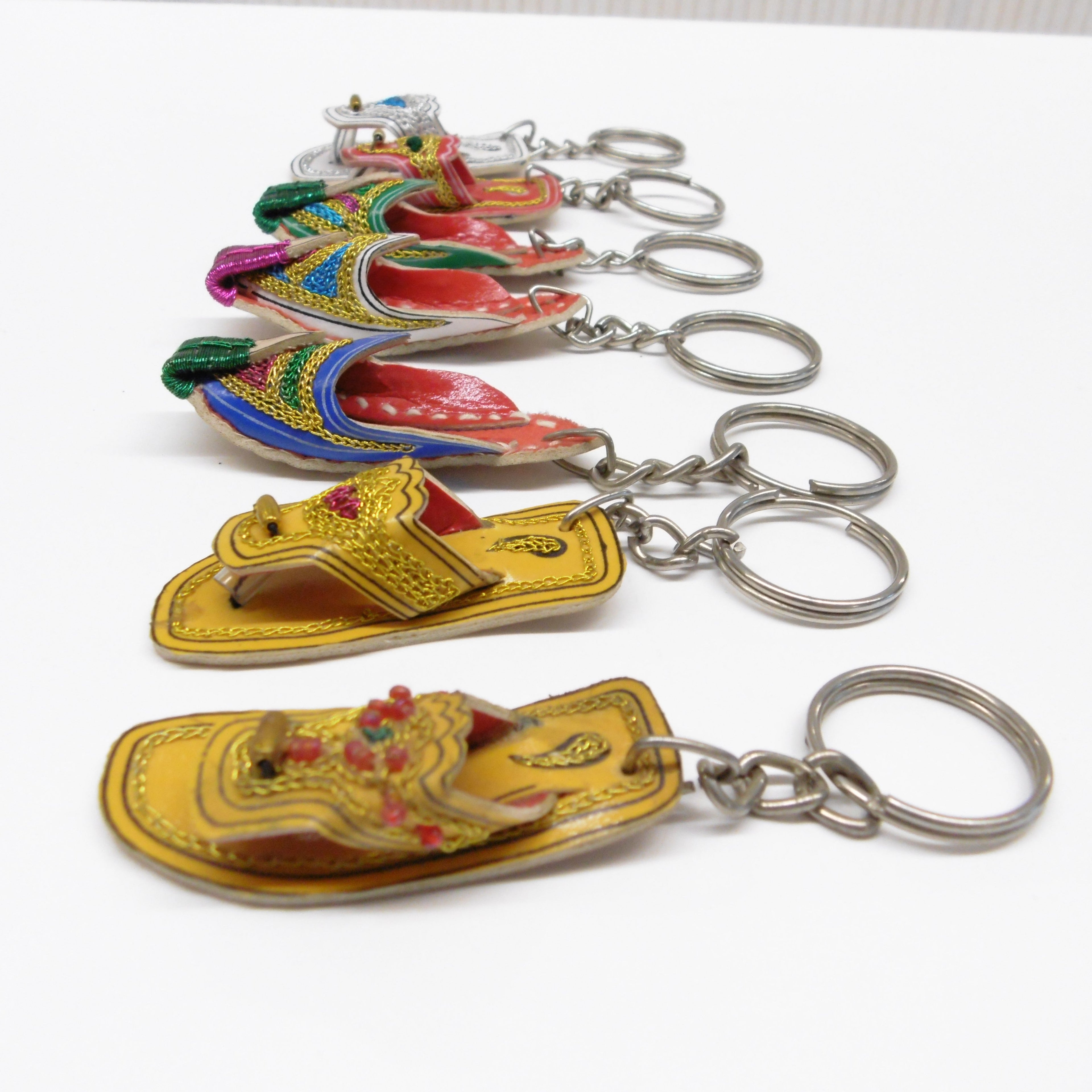 Close up side view of miniature leather Pakistani chappal keyrings with colourful embroidered detailing