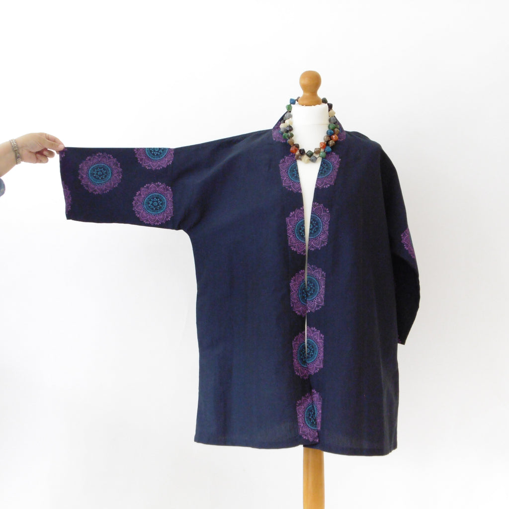 Navy blue jacket with purple circular patterns on a mannequin against a white background