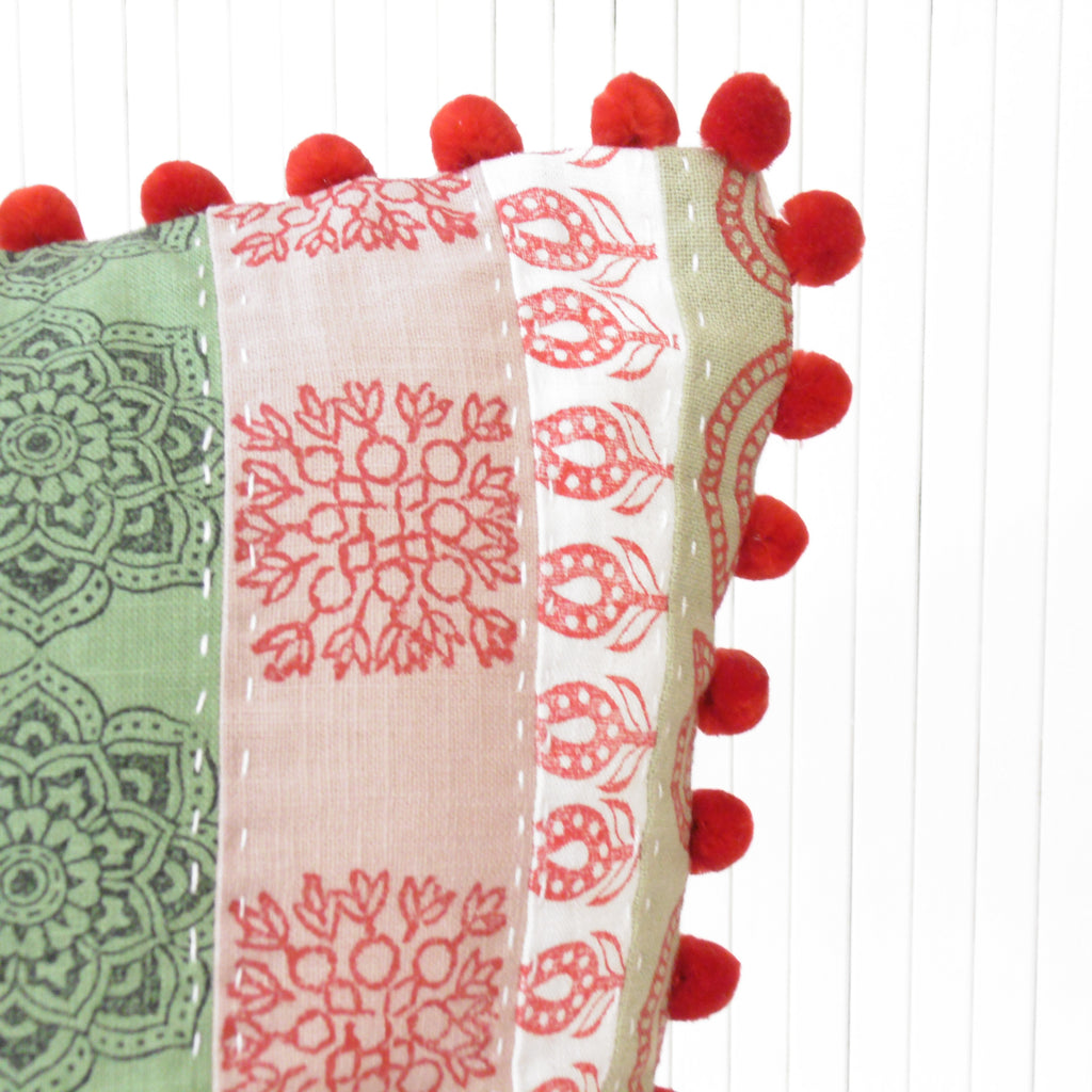 red fluffy pom poms on a cushion