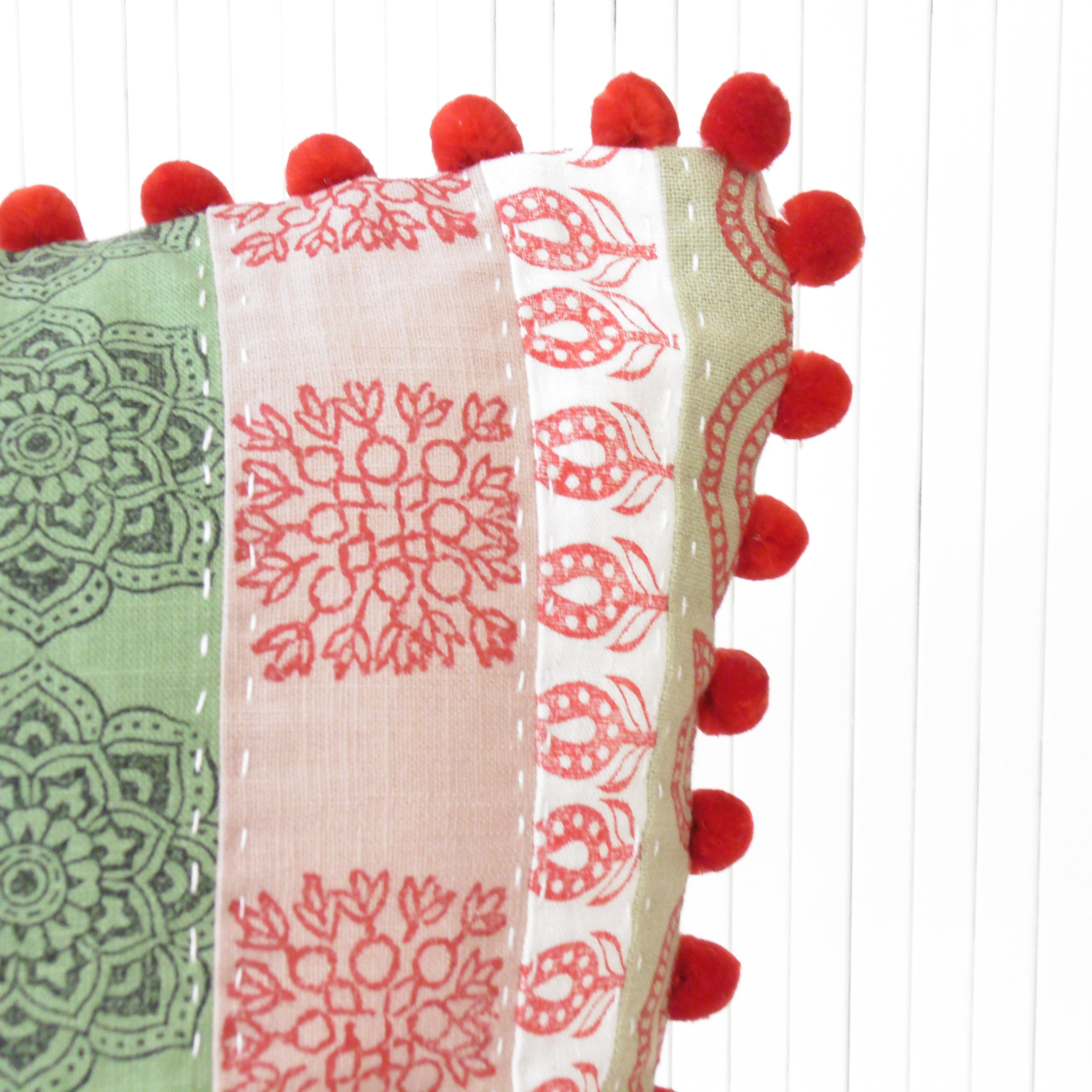 red fluffy pom poms on a cushion