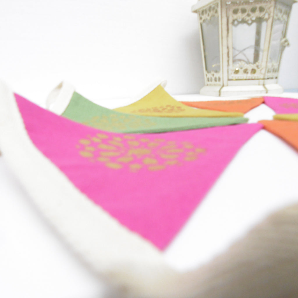 Colorful triangular table mats with decorative patterns on a white surface.