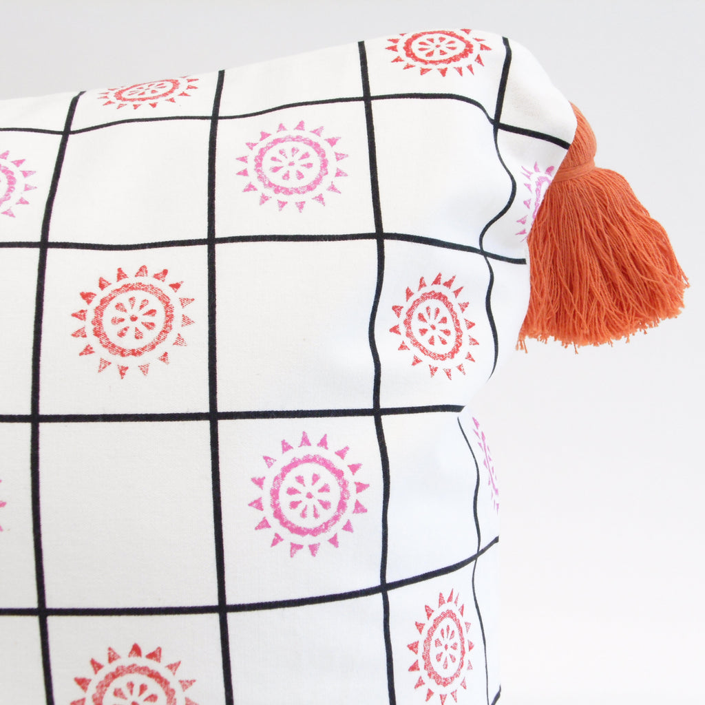 Decorative blanket with geometric patterns and tassels on a light gray background