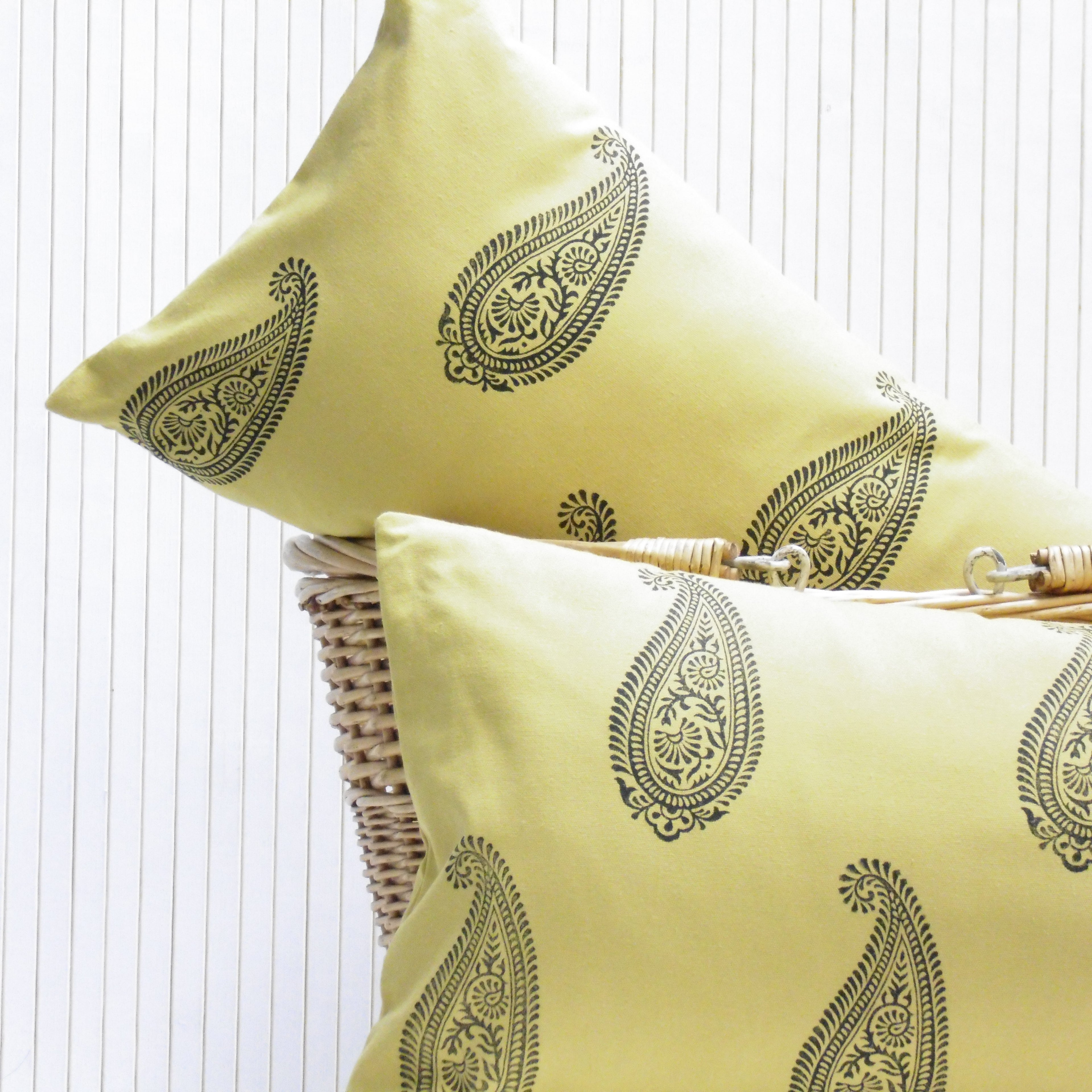 Two yellow pillows with black patterns on a white background