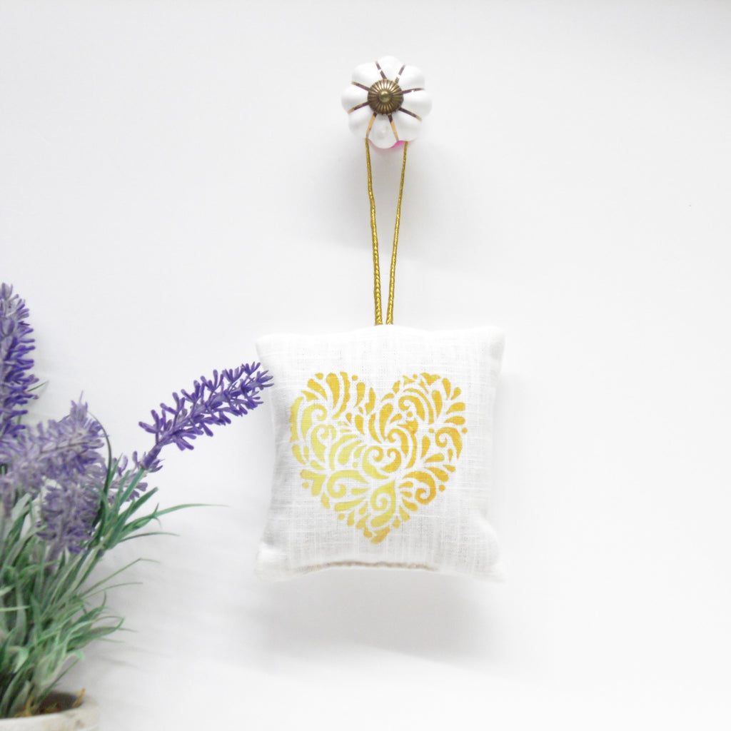 Decorative pillow with a yellow heart design on a white background