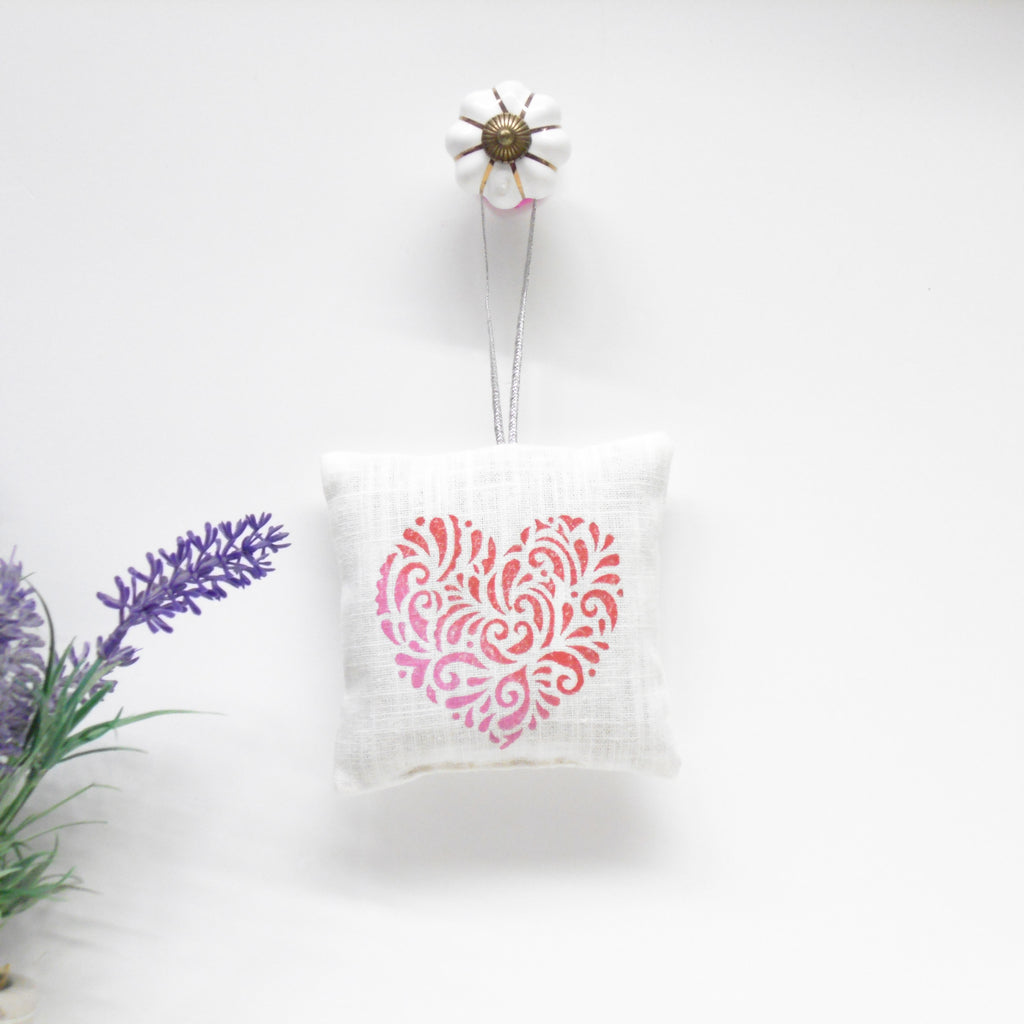 Decorative heart-shaped pillow with floral elements on a white background