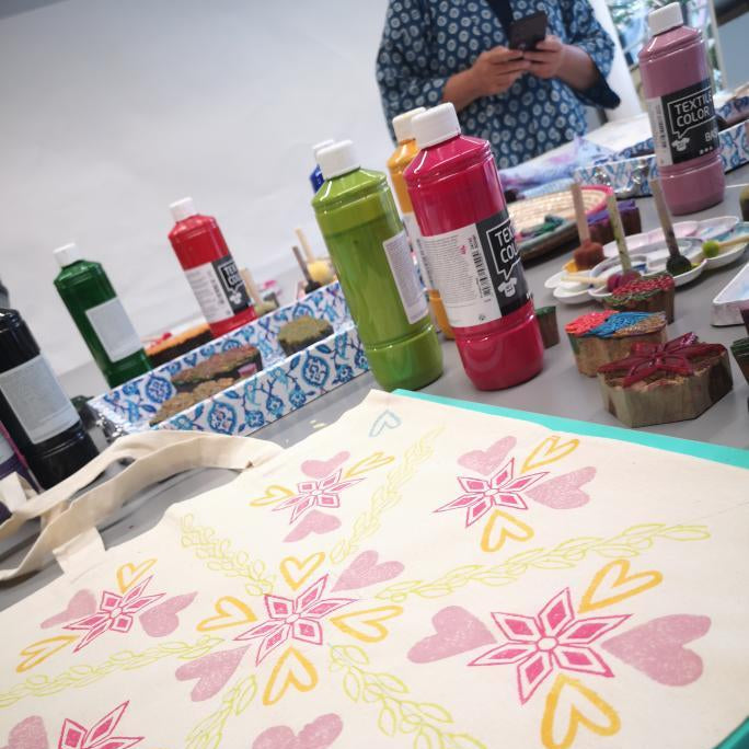 Colorful floral patterns on a mat with art supplies in the background