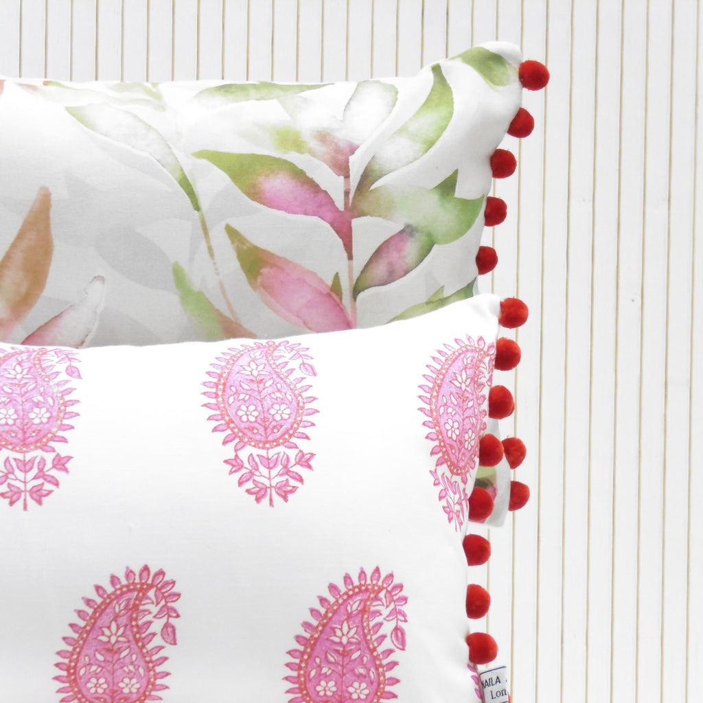 Two decorative pillows with floral and paisley patterns on a white background