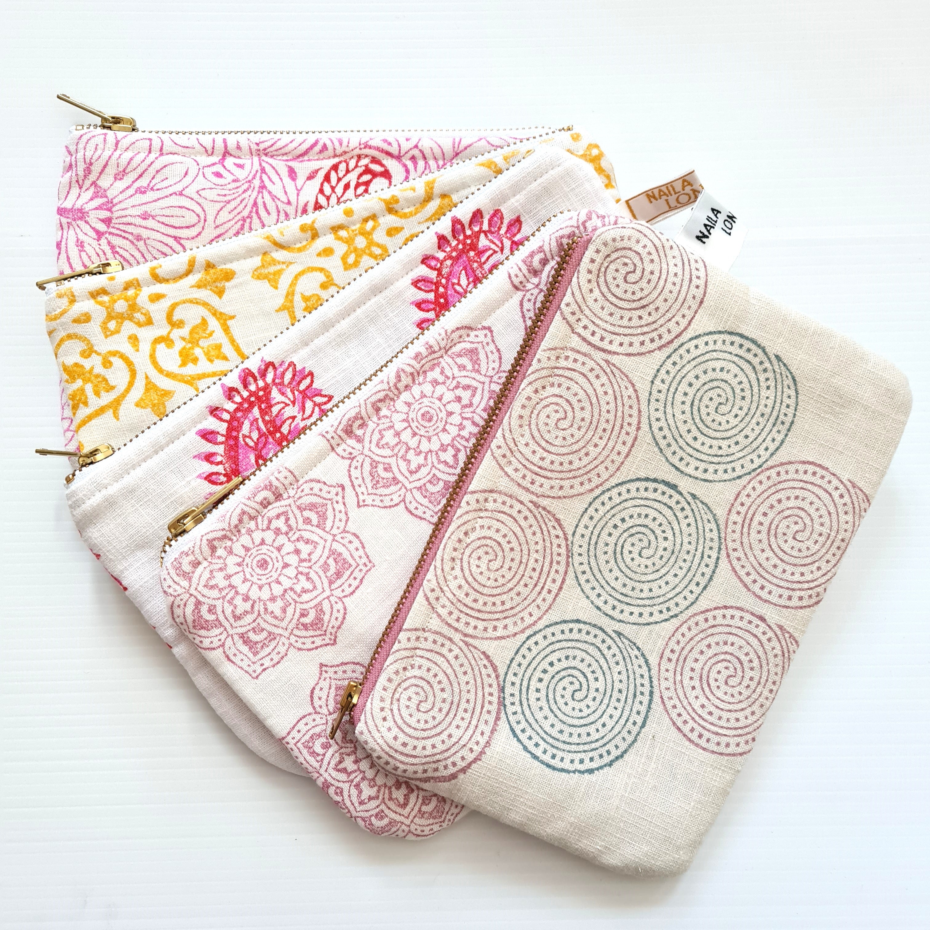 Set of four patterned pouches on a white background