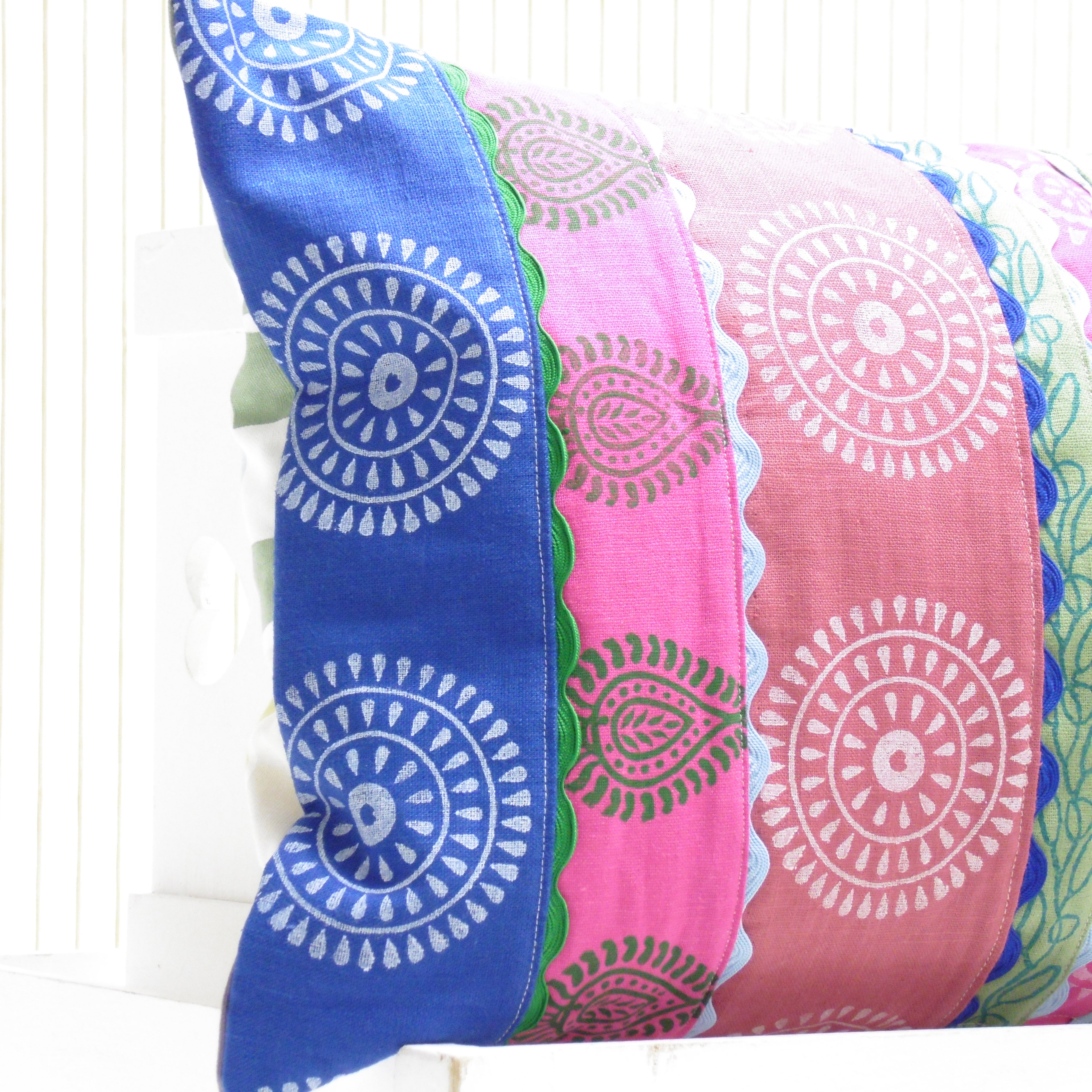Two colorful pillows with circular patterns on a white background