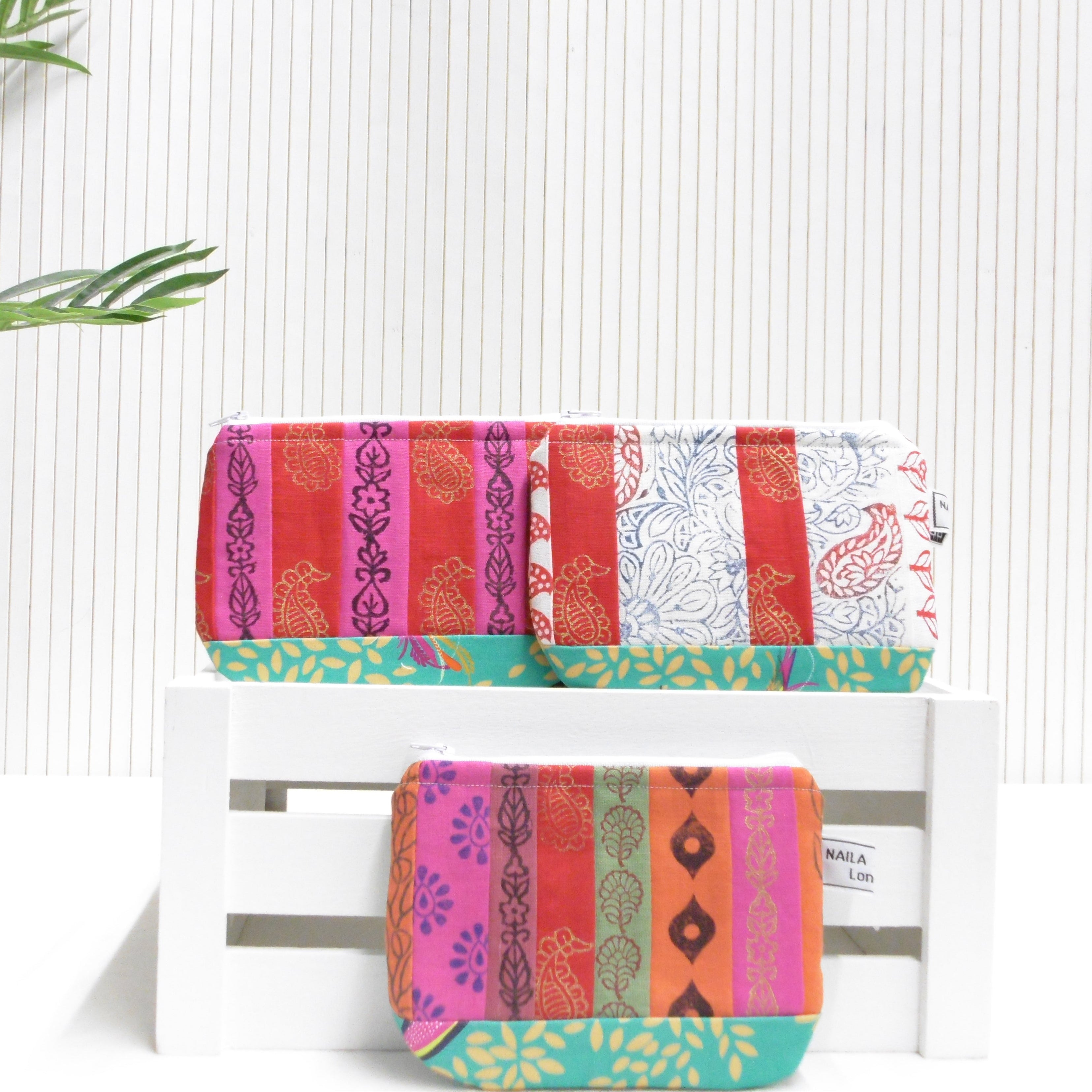 Colorful patterned towels on a white rack with a white background