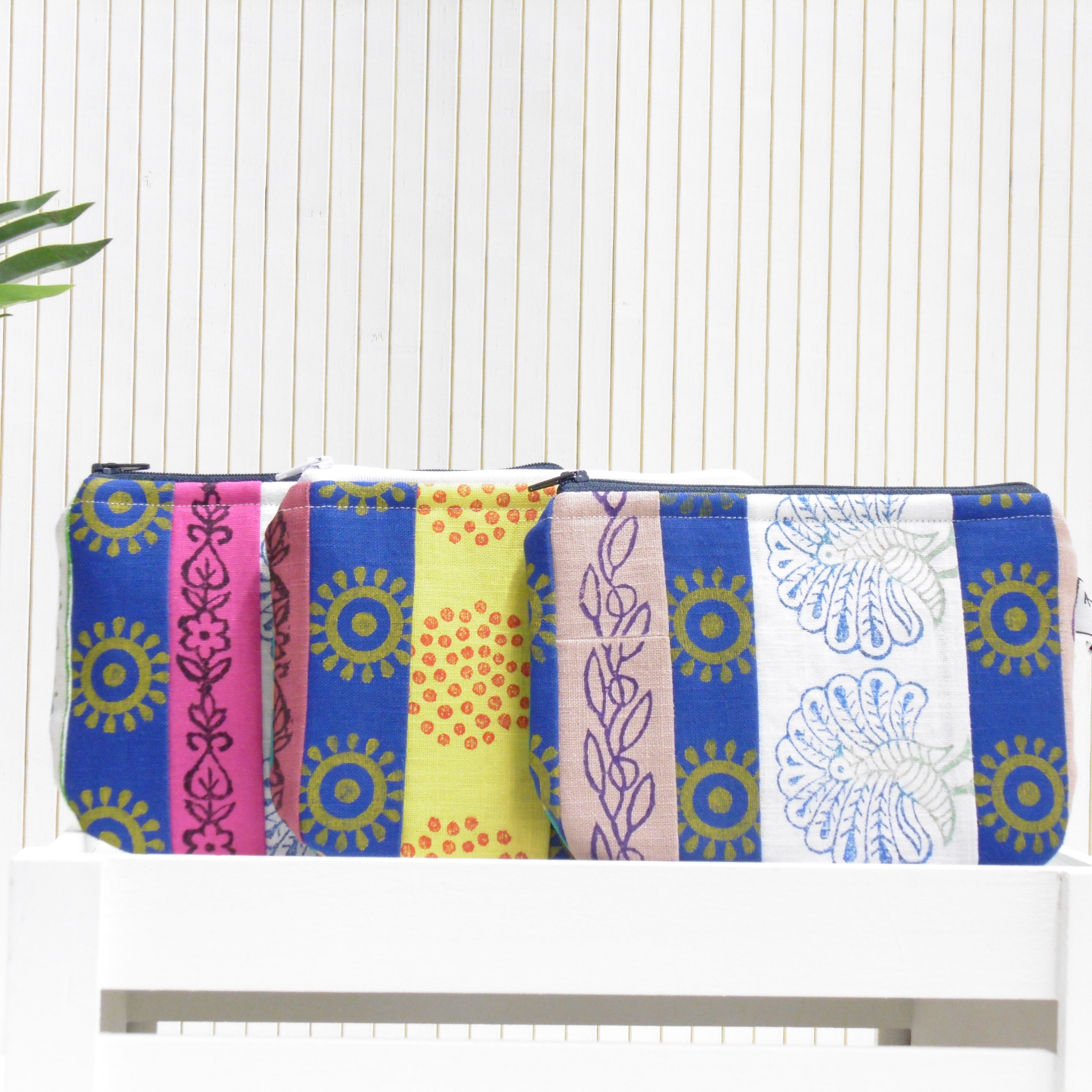 Set of four colorful pouches with patterned designs on a white surface.