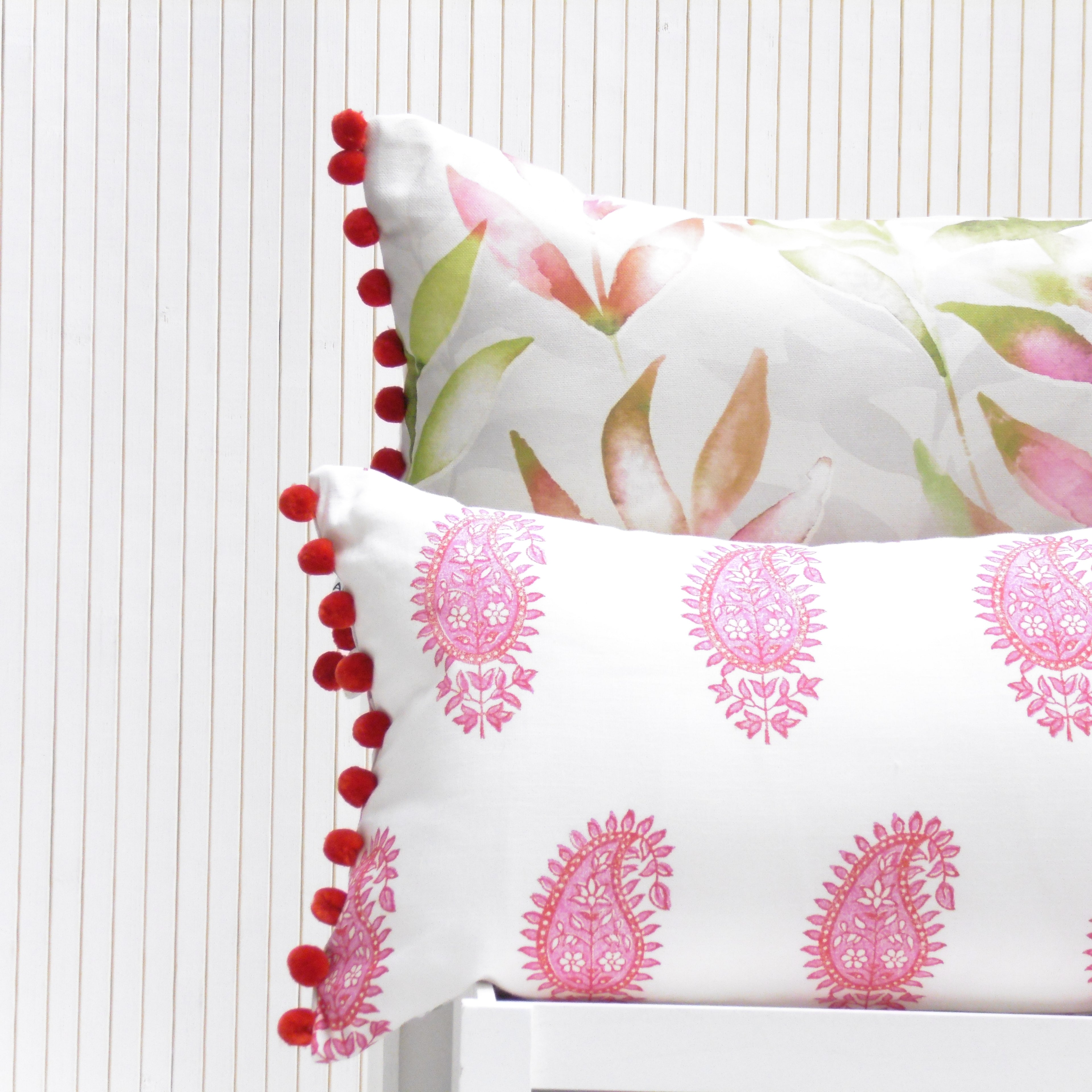 Two decorative pillows with floral and paisley patterns on a white background