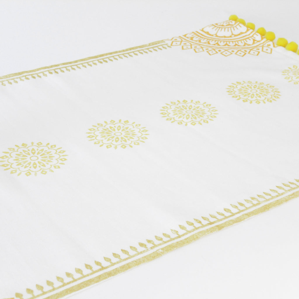 White fabric with gold embroidery on a white background
