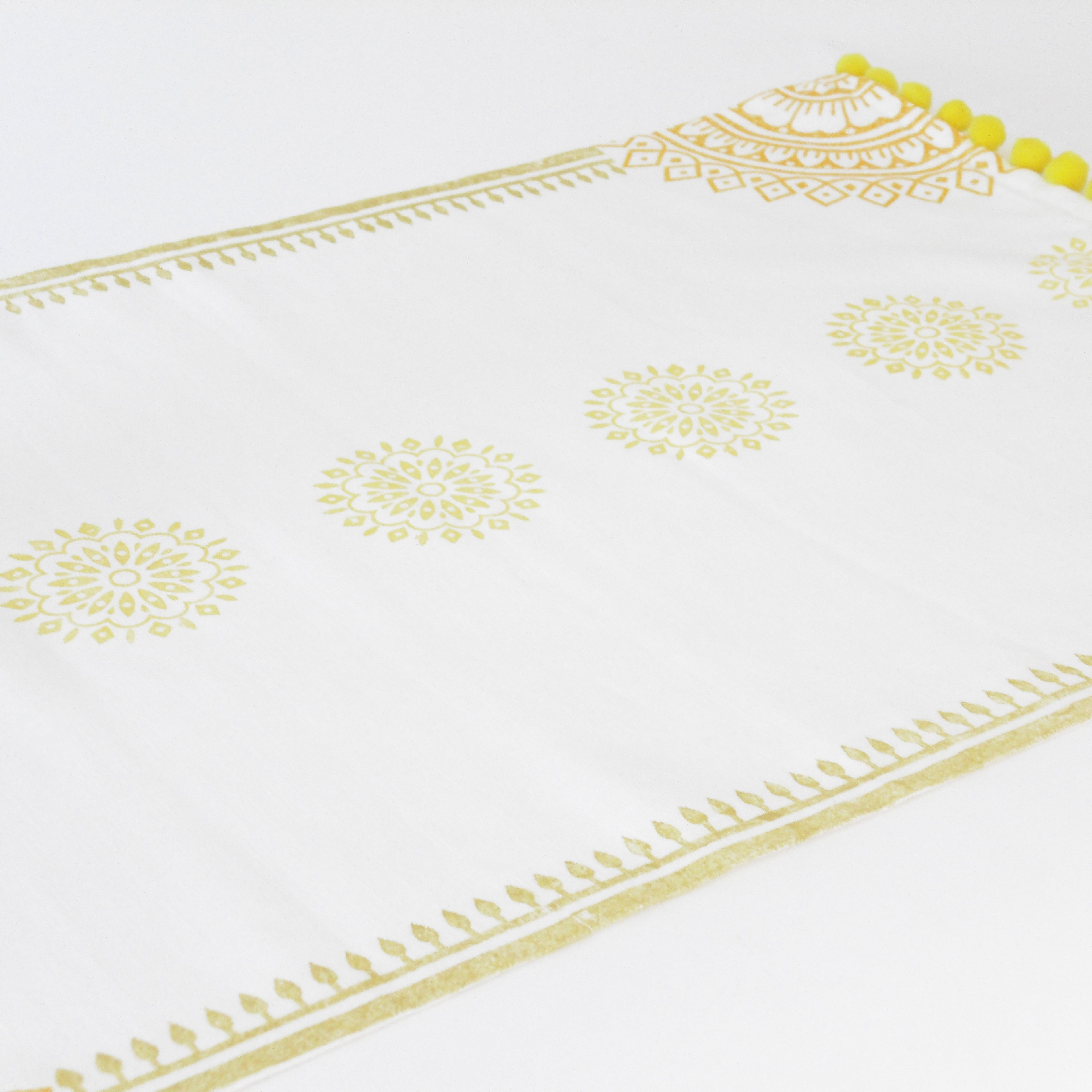 White fabric with gold embroidery on a white background