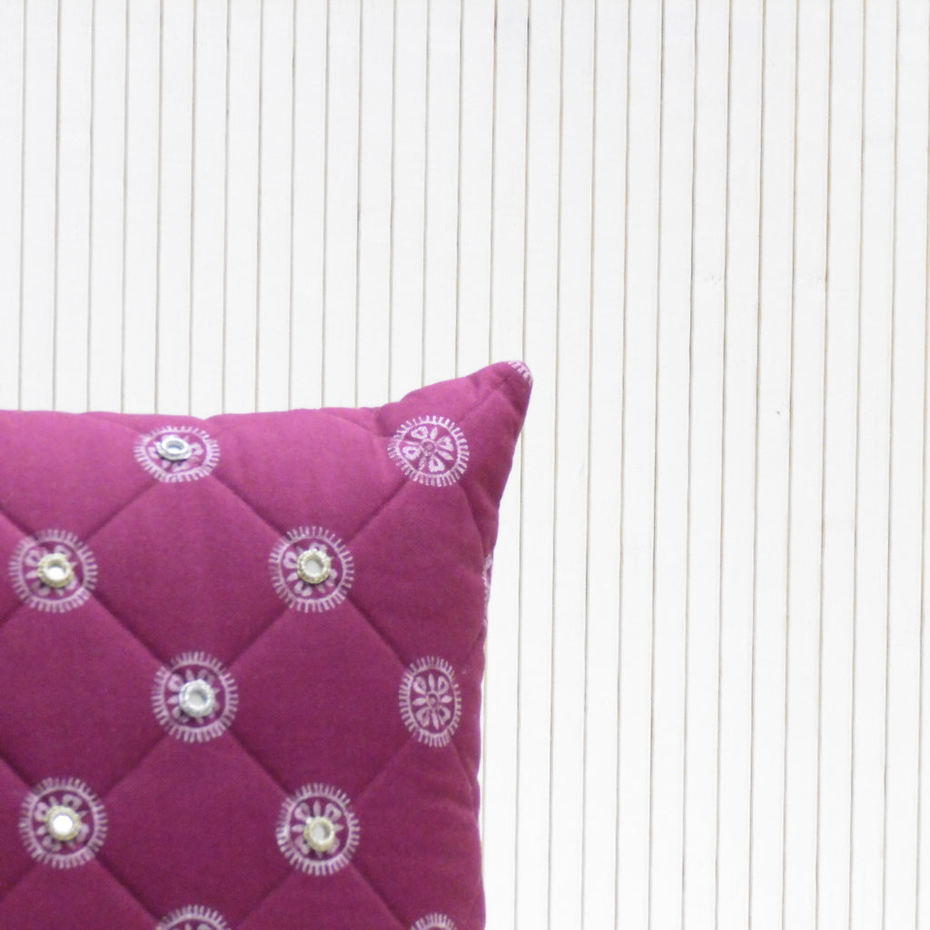 Purple pillow with decorative buttons on a white background