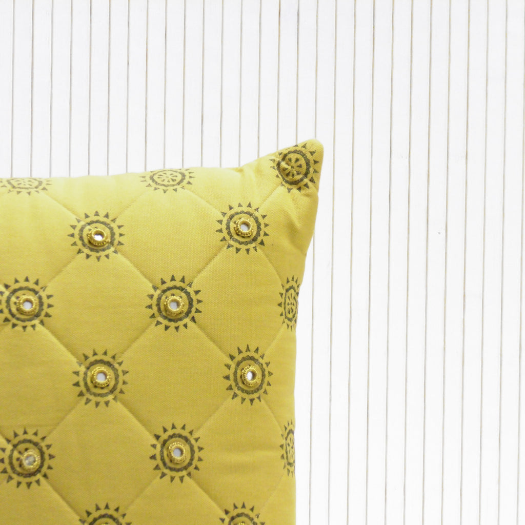 Yellow pillow with decorative patterns on a white background