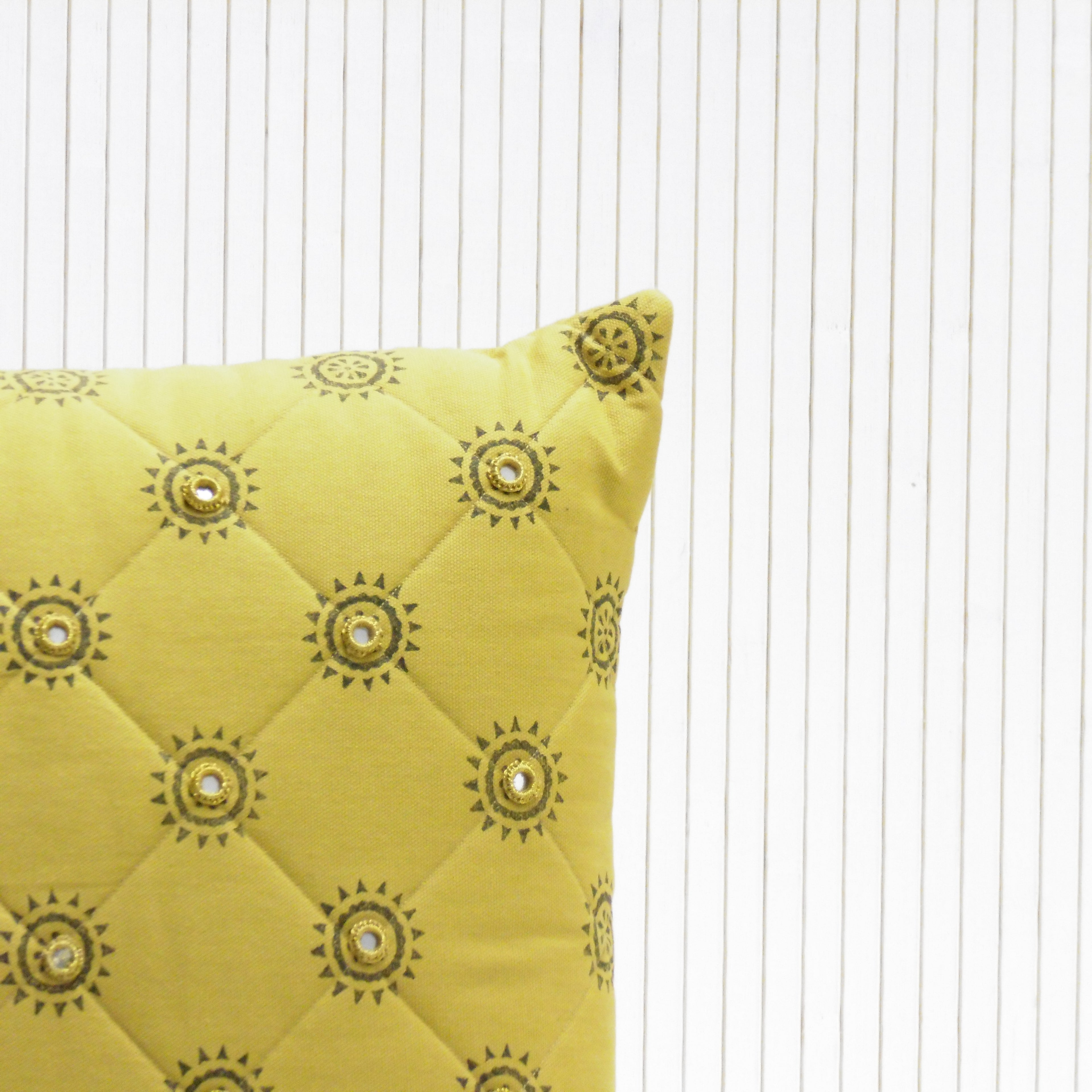 Yellow pillow with decorative patterns on a white background