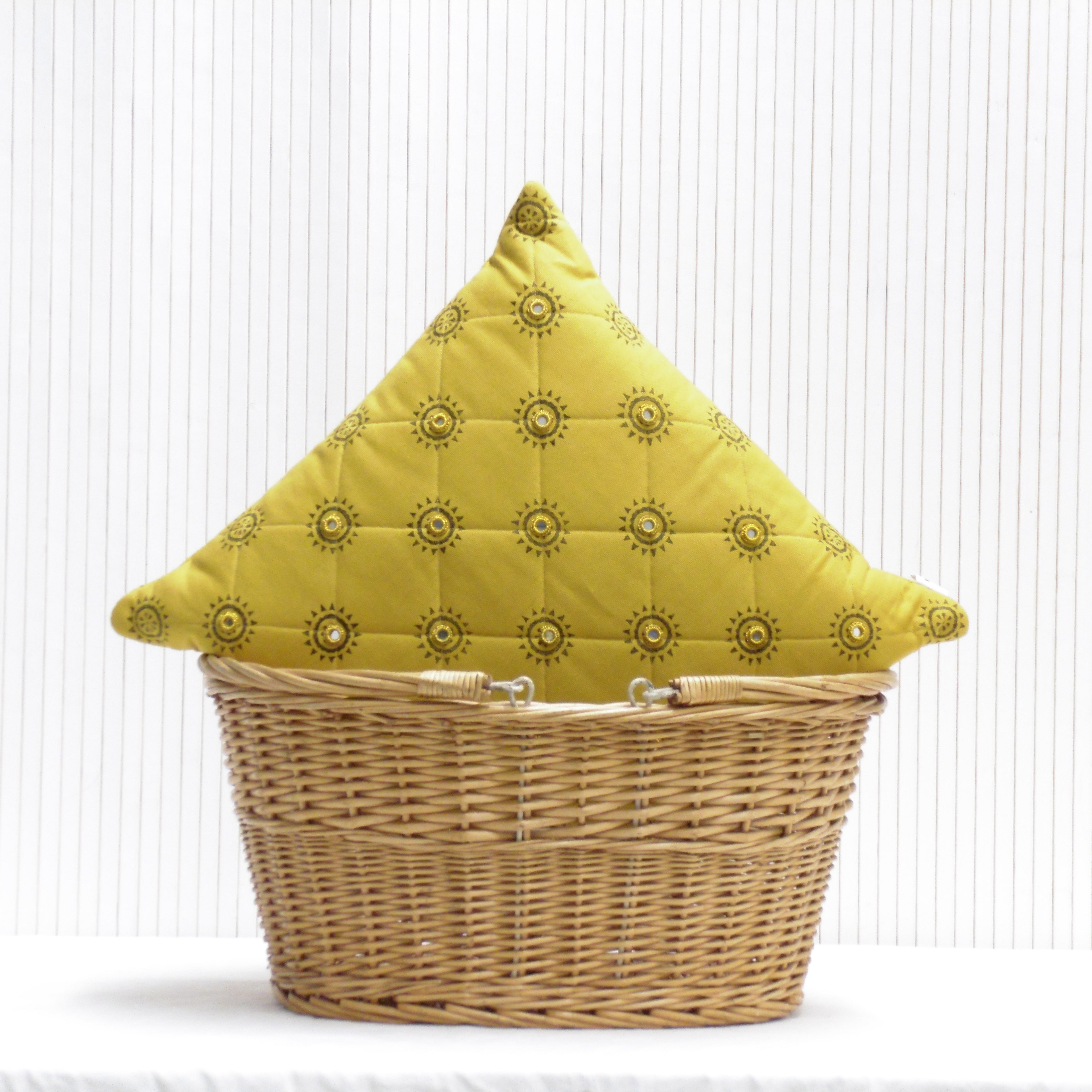 Wicker basket with a yellow quilted cover featuring sun patterns on a white background