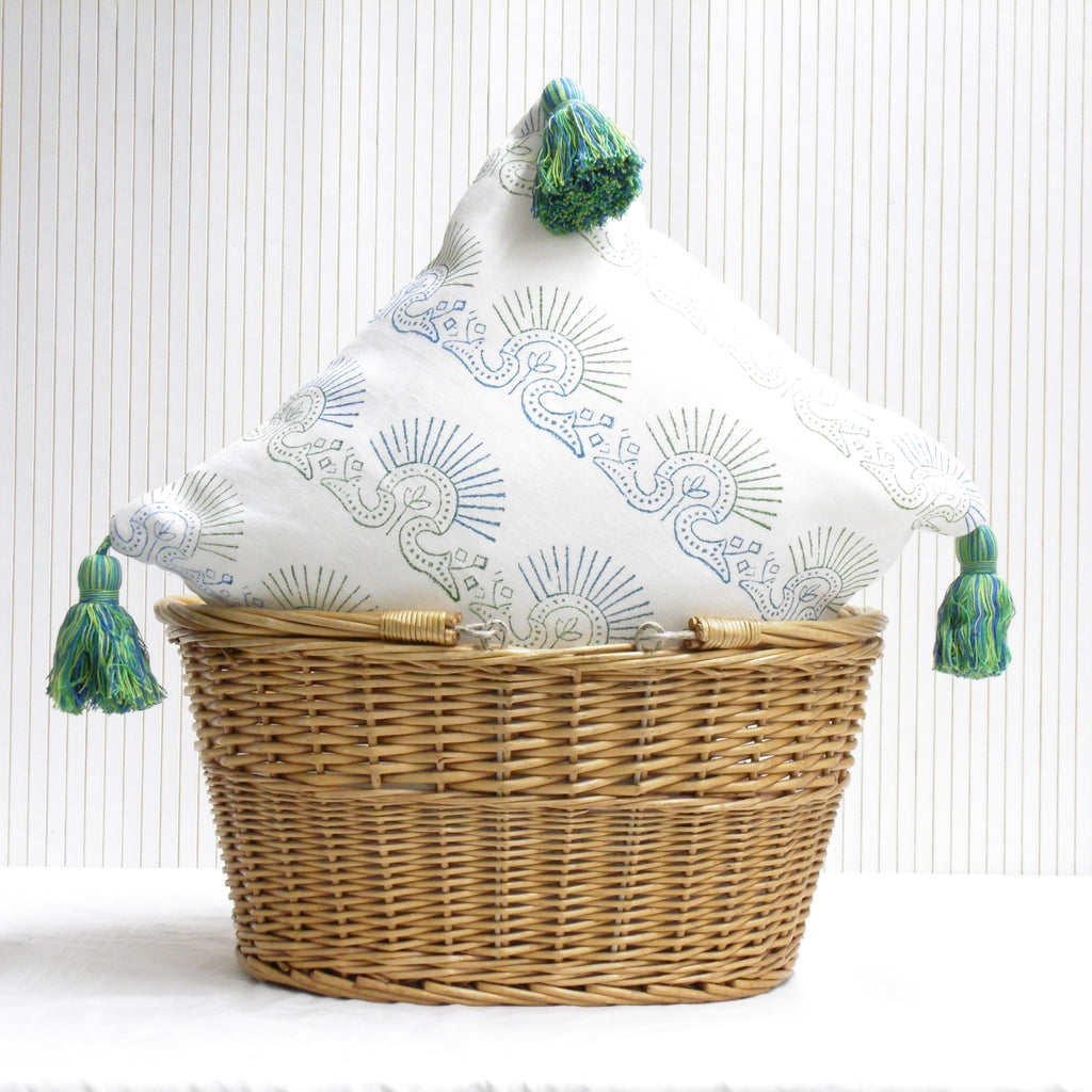 Decorative pillow with tassels in a wicker basket on a white background