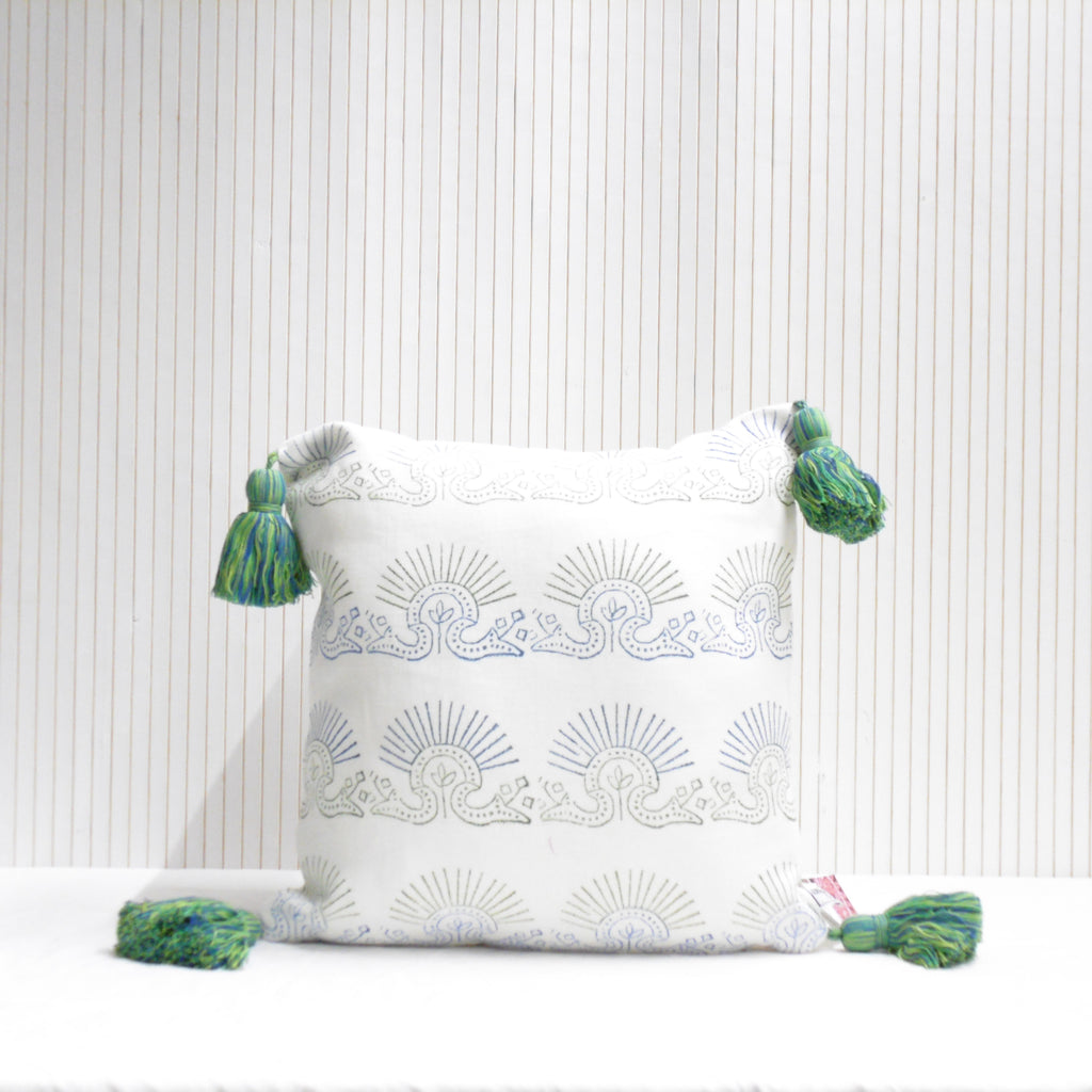 Decorative pillow with sunburst pattern and tassels on a white background