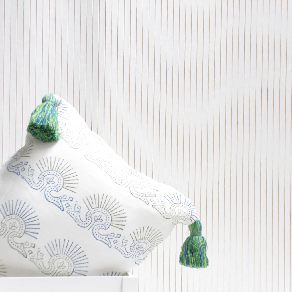 Decorative pillow with green tassels on a white background