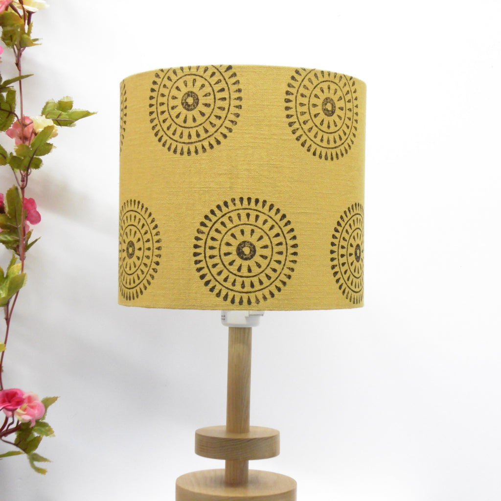 Yellow lampshade with black patterns on a white background