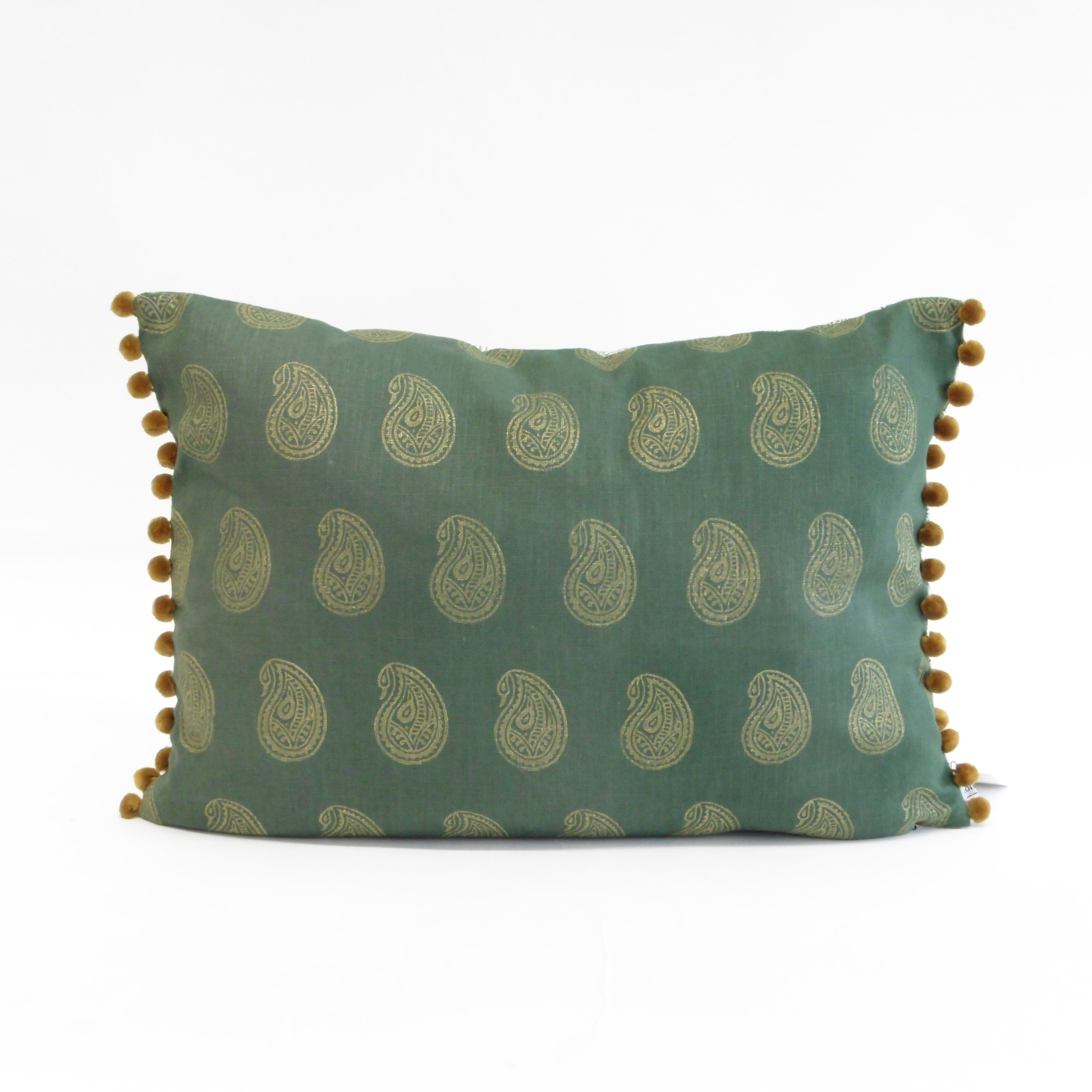 Green pillow with paisley pattern and pom-pom trim on a white background