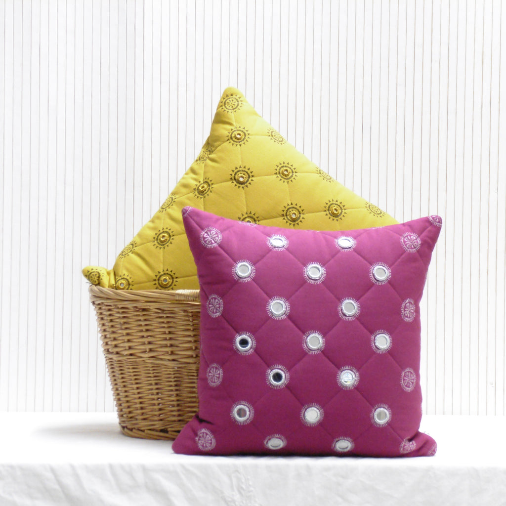 Yellow and pink patterned cushions on a white background