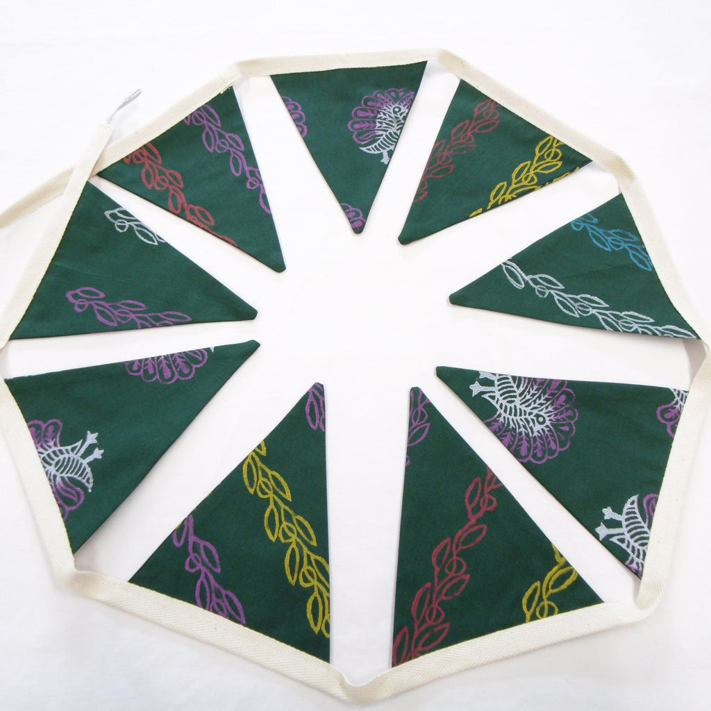 Full view of green hand block printed cotton bunting garland with peacock and vine motifs