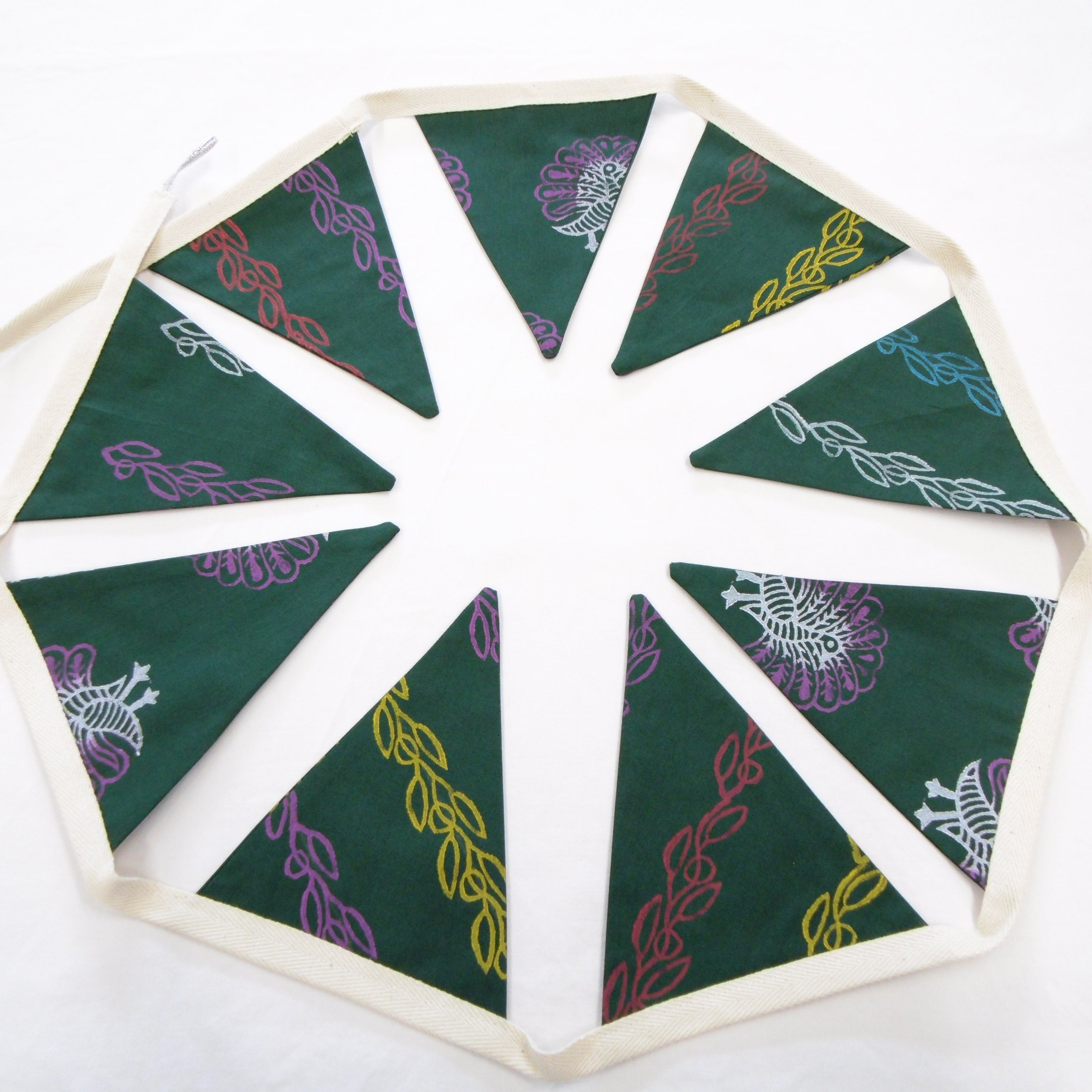 Full view of green hand block printed cotton bunting garland with peacock and vine motifs
