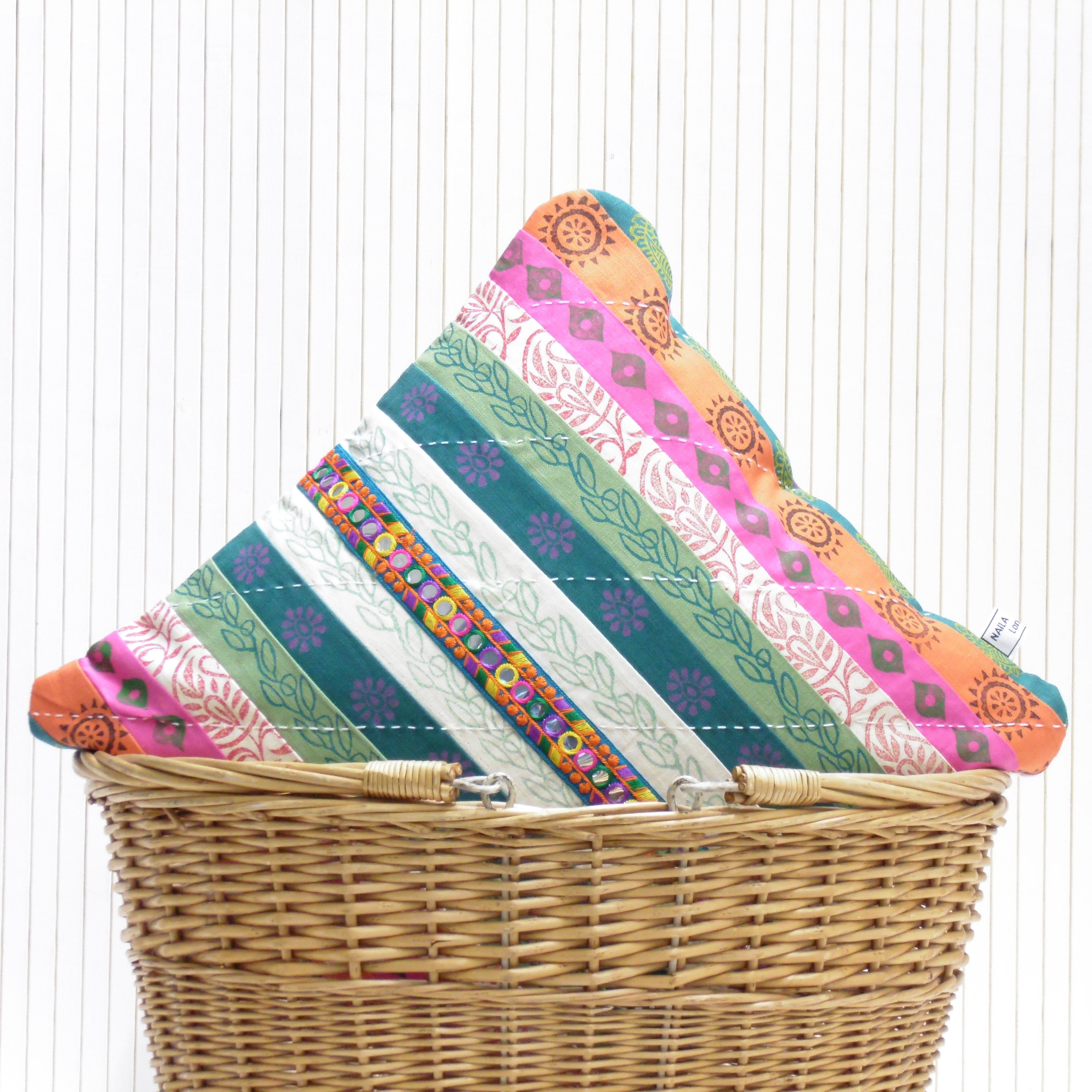 Stack of colorful fabric panels on a wicker basket with a white background