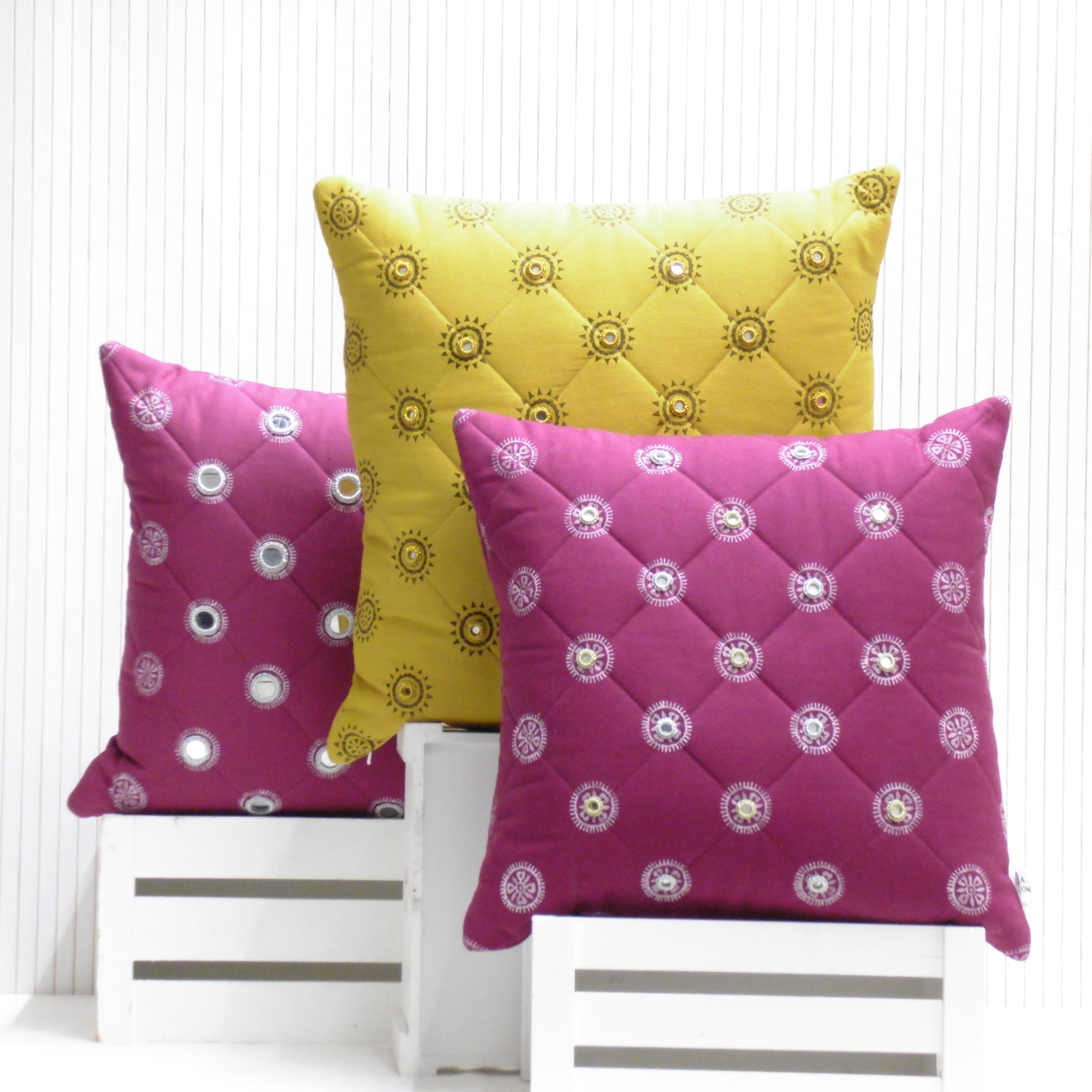 Three decorative pillows with floral patterns on a white background