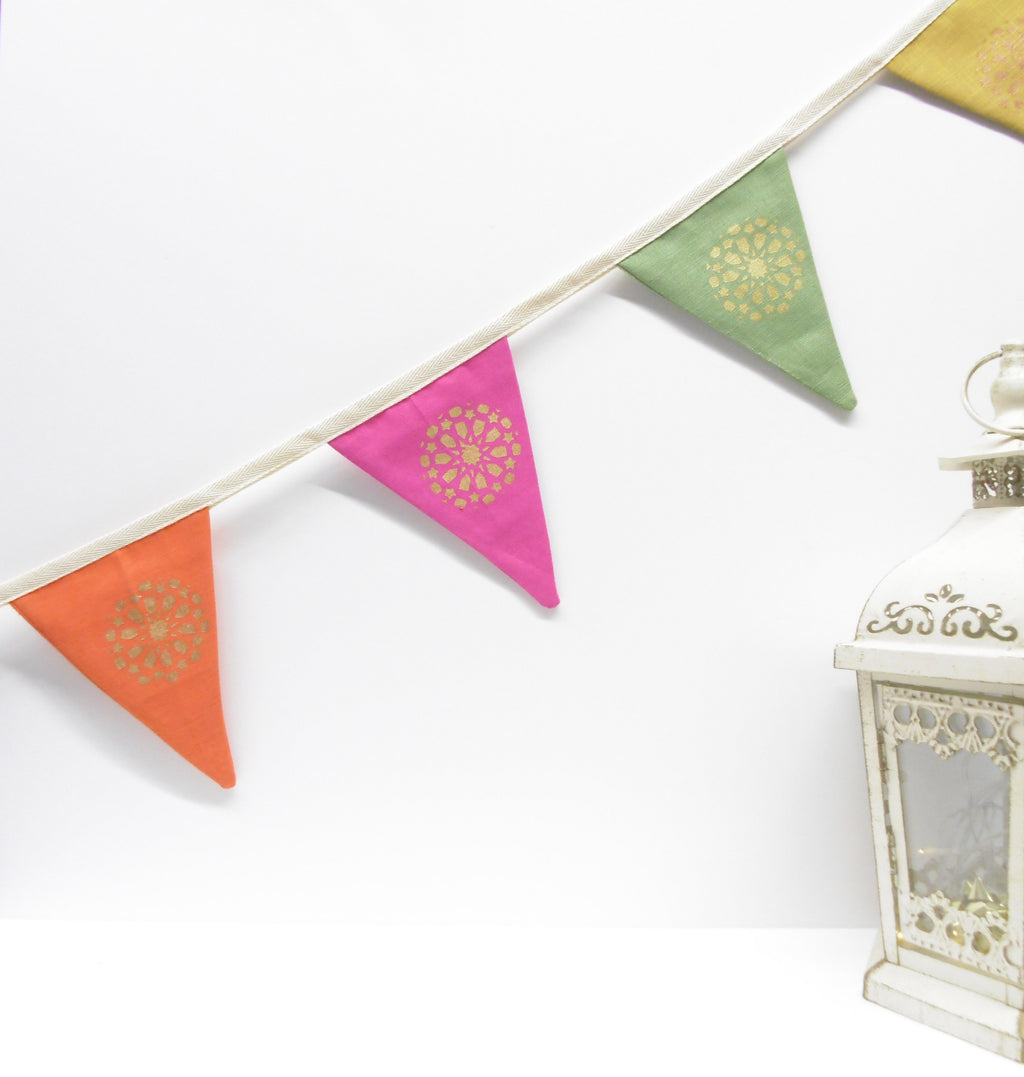 Colorful triangular flags on a string with a white lantern in the background
