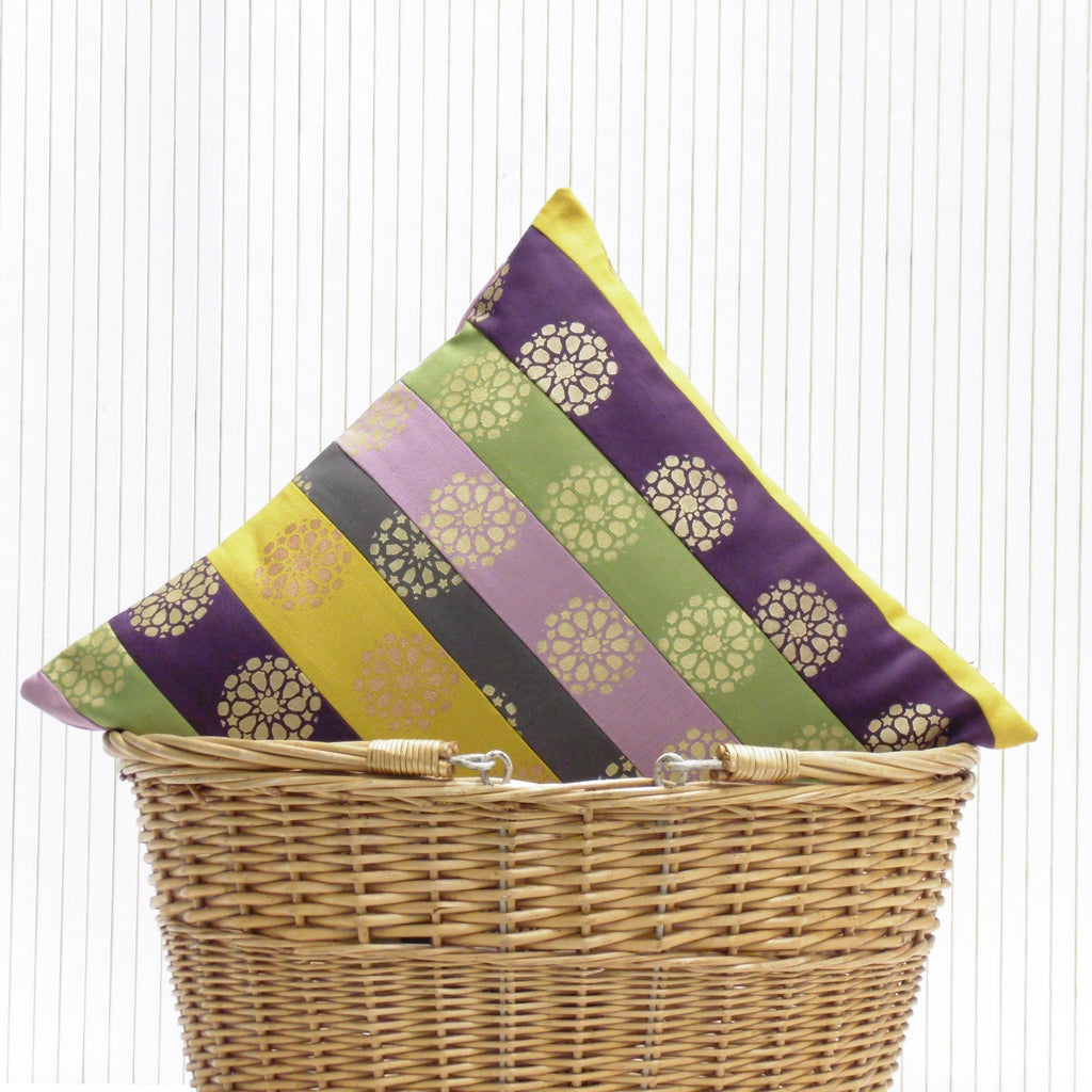 Wicker basket with a decorative purple, green, and yellow cover on a white background