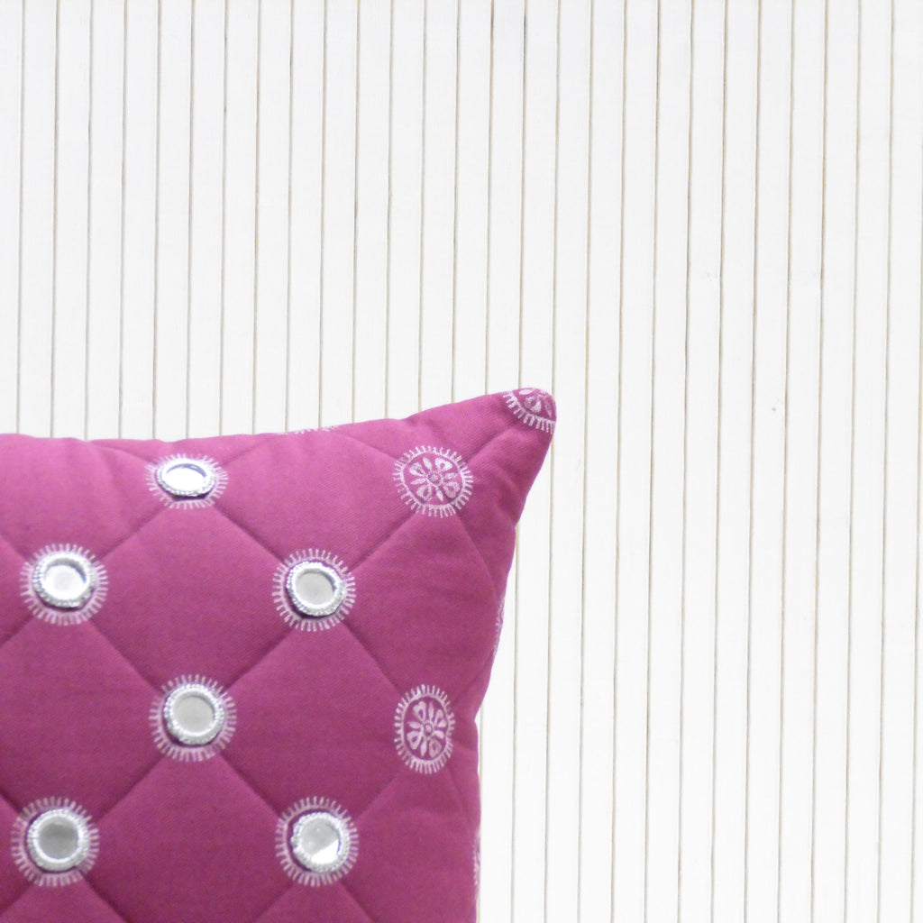 Purple pillow with decorative buttons on a white background